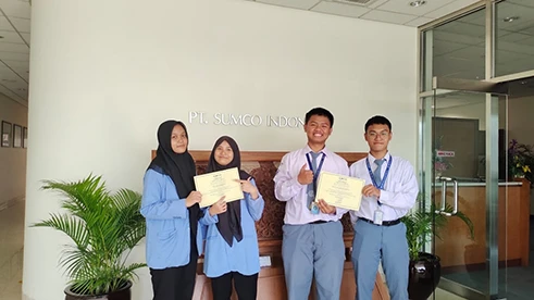 A commemorative photo of four participants holding their certificates at the Apprenticeship Program completion ceremony.