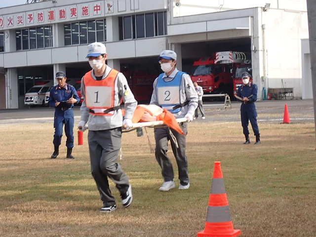 Scene from a fire initial response competition: Participants transporting a person acting as a victim.
