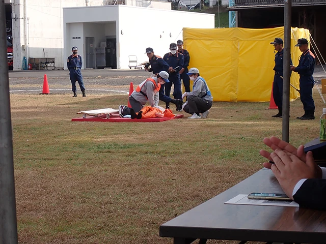 Scene from a fire initial response competition: A participant performing chest compressions on a medical mannequin.